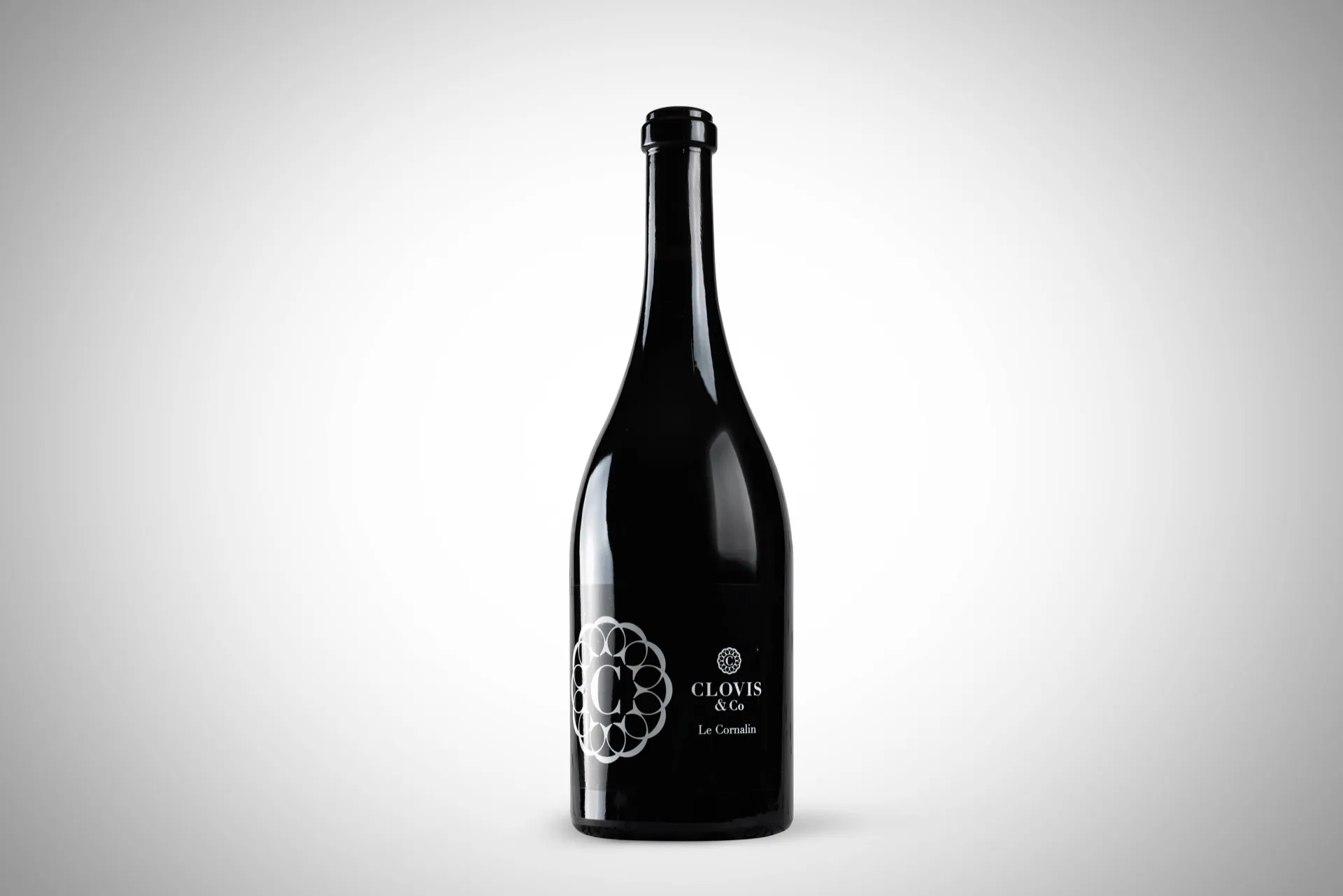 Bouteille de vin rouge sur fond dégradé neutre, étiquette gravée — packshot studio réalisé pour Clovis & Co