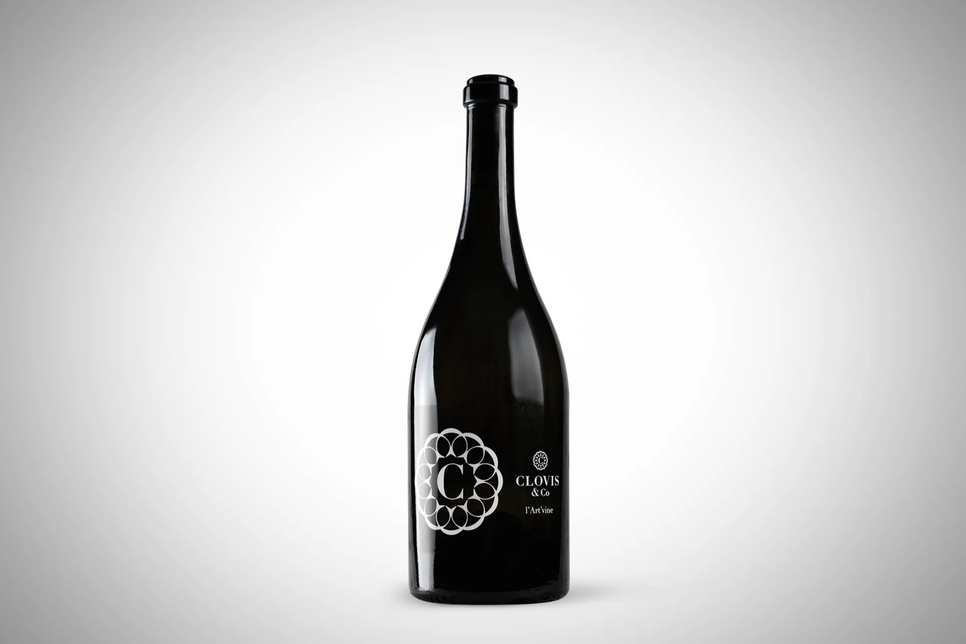 Bouteille de vin en verre clair sur fond neutre, packshot studio réalisé pour Clovis & Co
