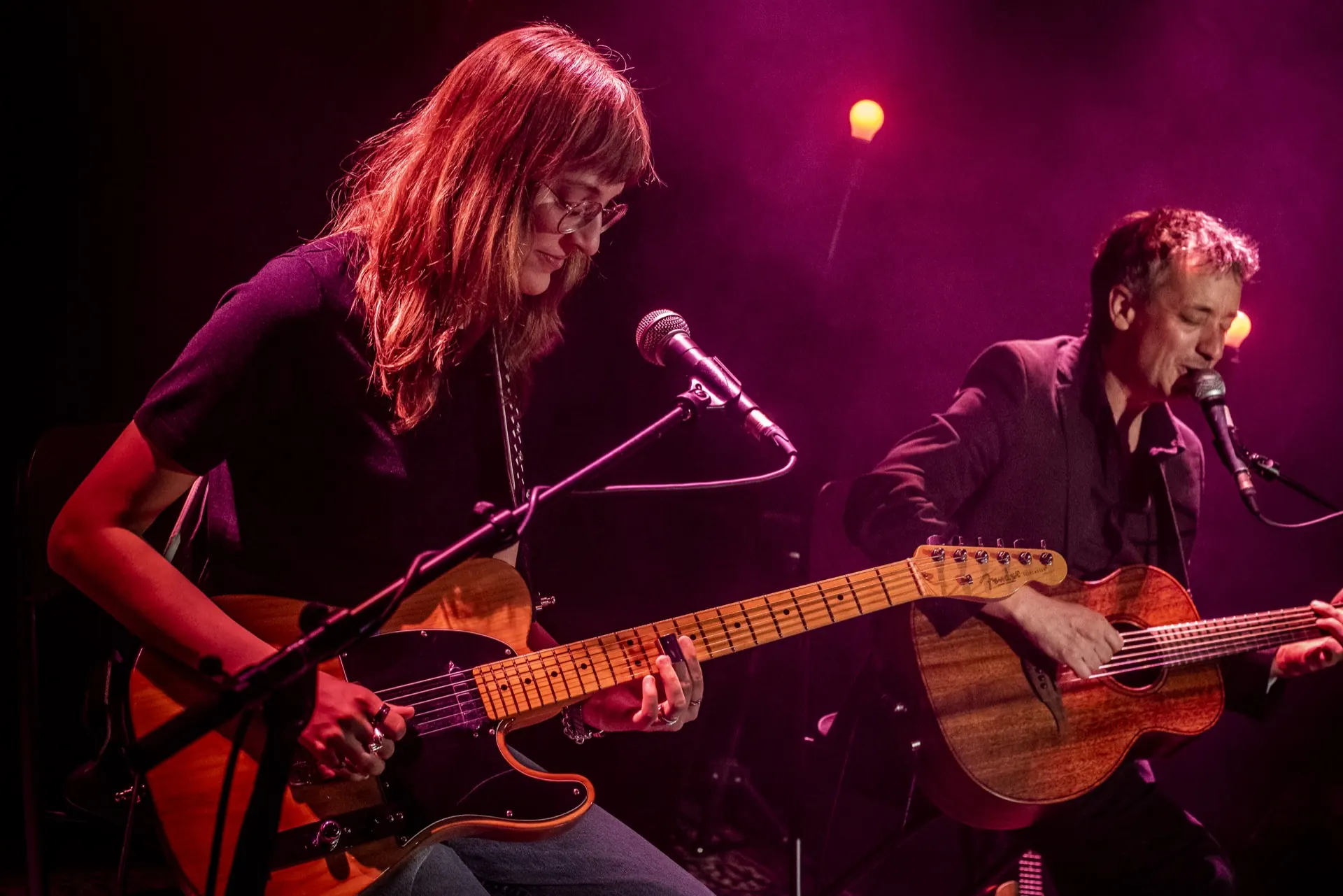 Guitariste à la Telecaster et chanteur à l'acoustique aux micros, ambiance rose vif.