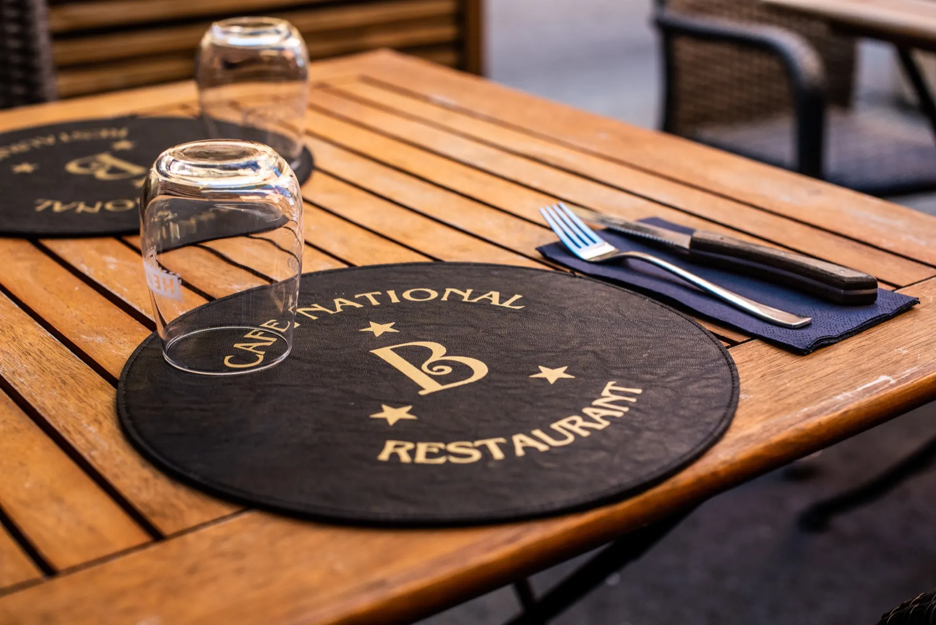 Set de table en ardoise au logo du Café National, verres et couverts sur bois