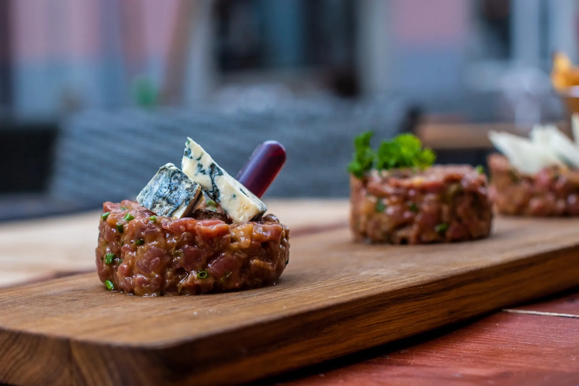 Tartare de bœuf garni de bleu, couteau à côté, servi en terrasse